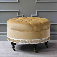 Velvet ottoman in elegant room with molding details.