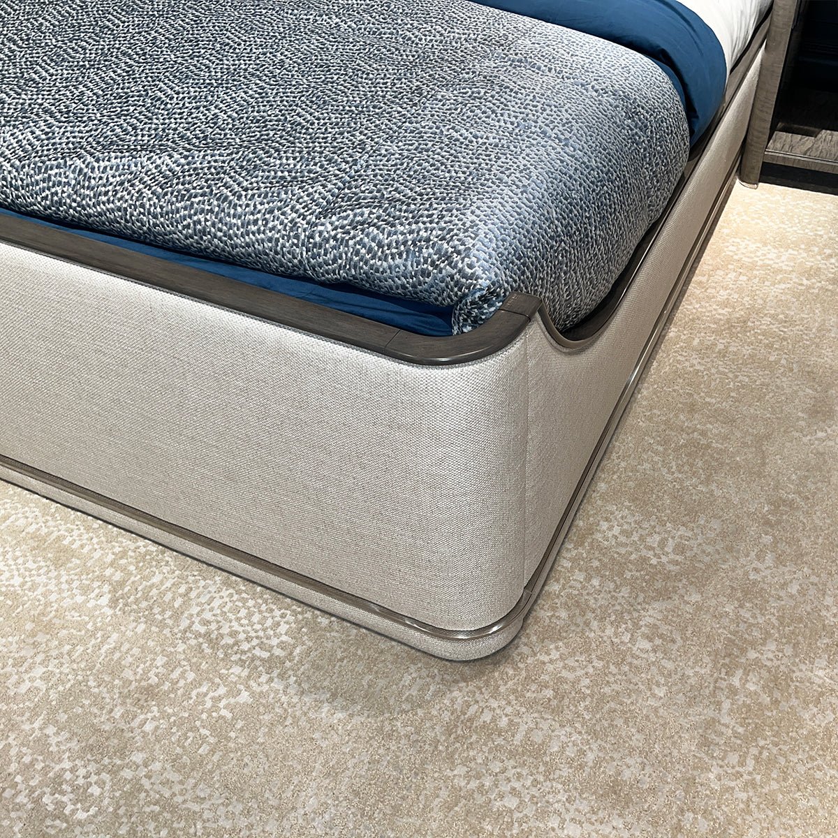 Close-up of upholstered Art Deco bed corner and bedding.