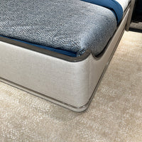 Close-up of upholstered Art Deco bed corner and bedding.