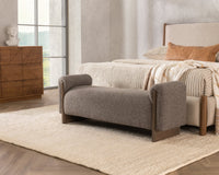 Bronzed Cocoa upholstered bench with ash end supports at the foot of a bed