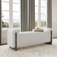 Sand upholstered bench with ash end supports beside tall windows, with books on the seat