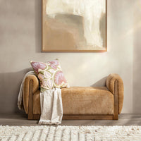 Spiced Amber upholstered bench styled with a floral pillow and fringed throw beneath abstract artwork