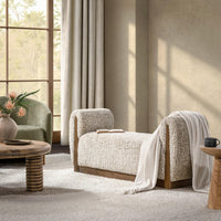Wheatfield bench with curved arms in a sunlit living room, styled with an open book and a draped throw