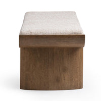 End view of the upholstered bench showing a broad rounded parawood support beneath the pale cushion