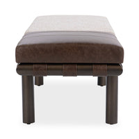 End view of the bench showing its brown leather cushion, straps and cylindrical iron legs