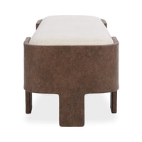 End view of the upholstered bench showing a curved brown wrapped support around the pale cushion