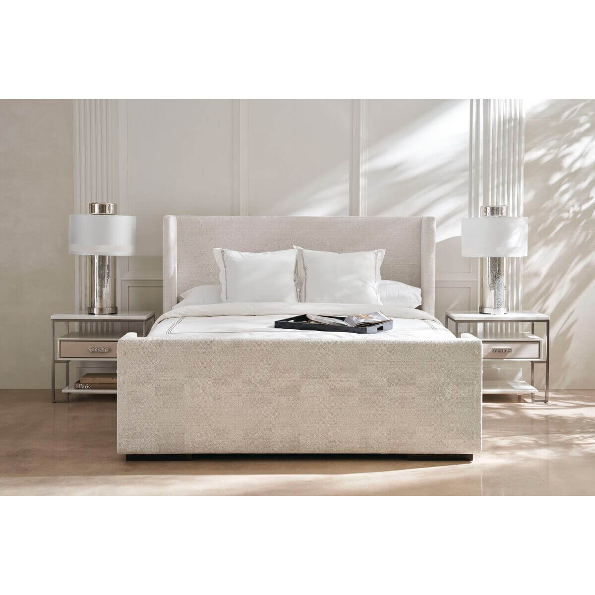 Bedroom scene with upholstered queen bed, twin nightstands.