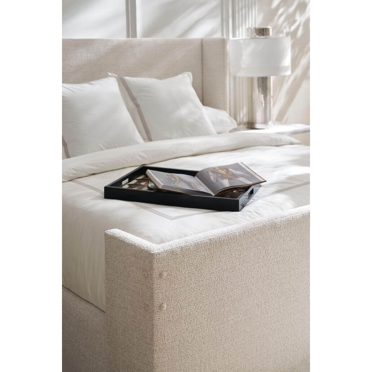 Close-up, bed with book tray and bedding.