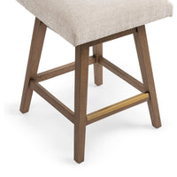 Close-up of the brown parawood base and brass-toned front footrest beneath the cream seat