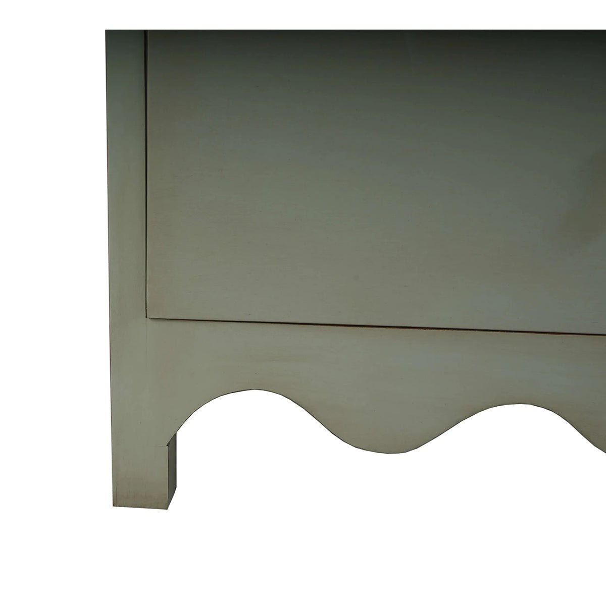 Close-up scalloped base of vintage fennel green dresser.