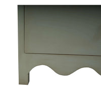 Close-up scalloped base of vintage fennel green dresser.