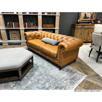 Chesterfield sofa in living room setting with decor elements.