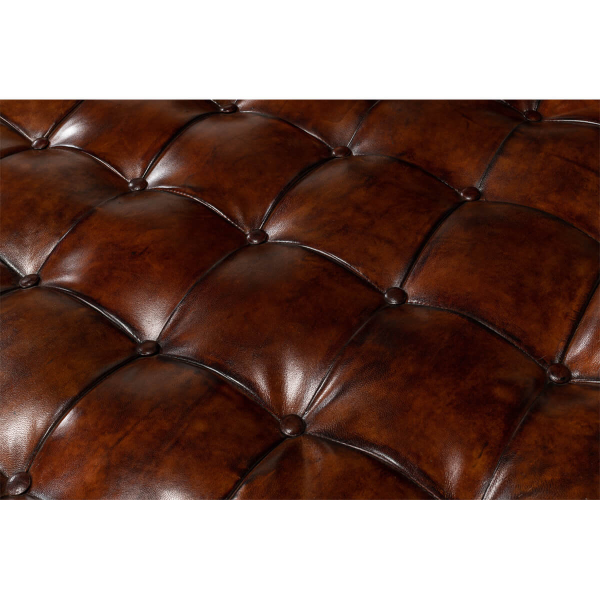 Close-up of tufted leather upholstery on ottoman.