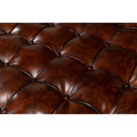 Close-up of tufted leather upholstery on ottoman.
