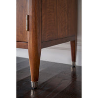 Close-up of walnut Art Deco cabinet leg with metal tip.