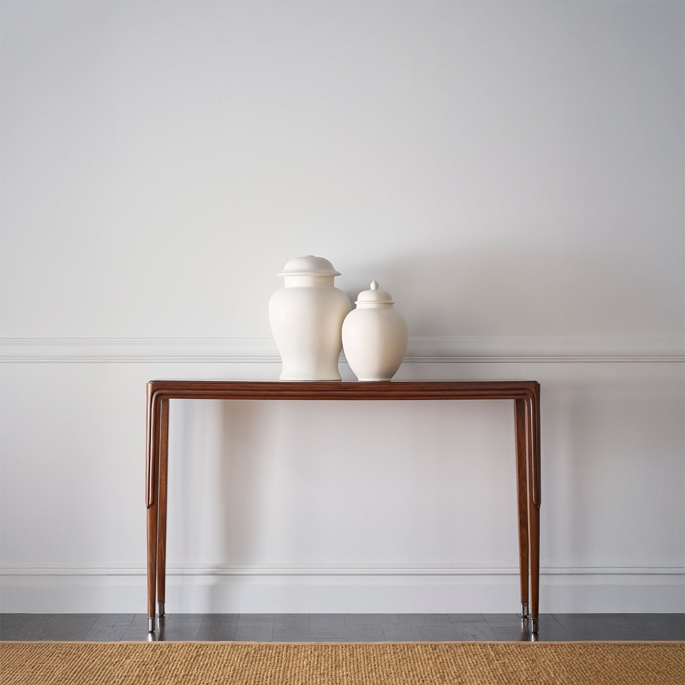 Console table with decorative vases, minimalistic space.