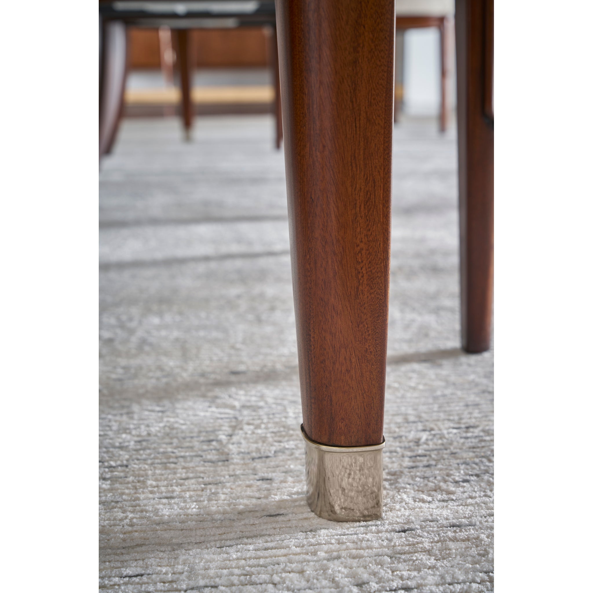 Close-up of dining table leg with metallic detail.