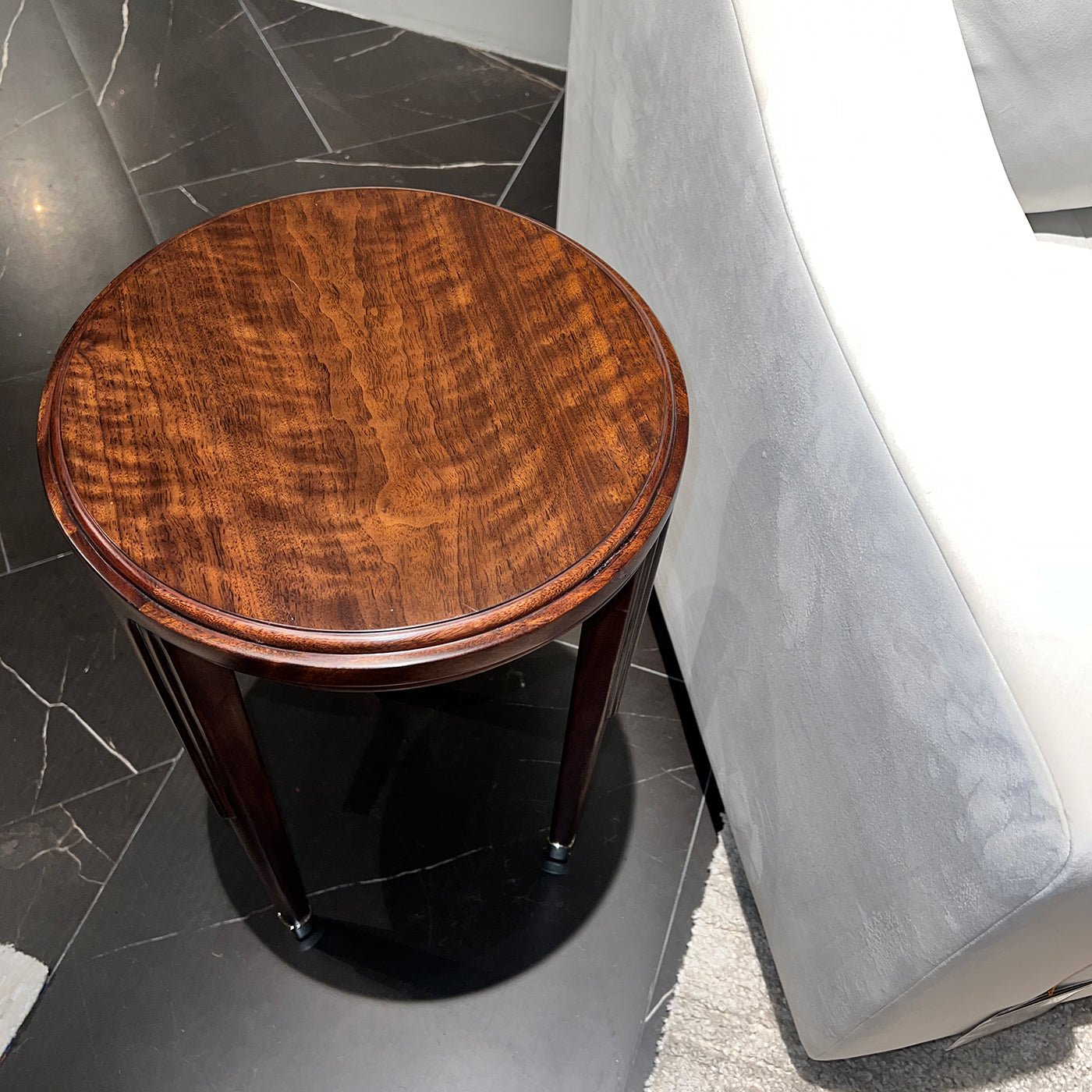 Top view of walnut art deco accent table next to sofa.