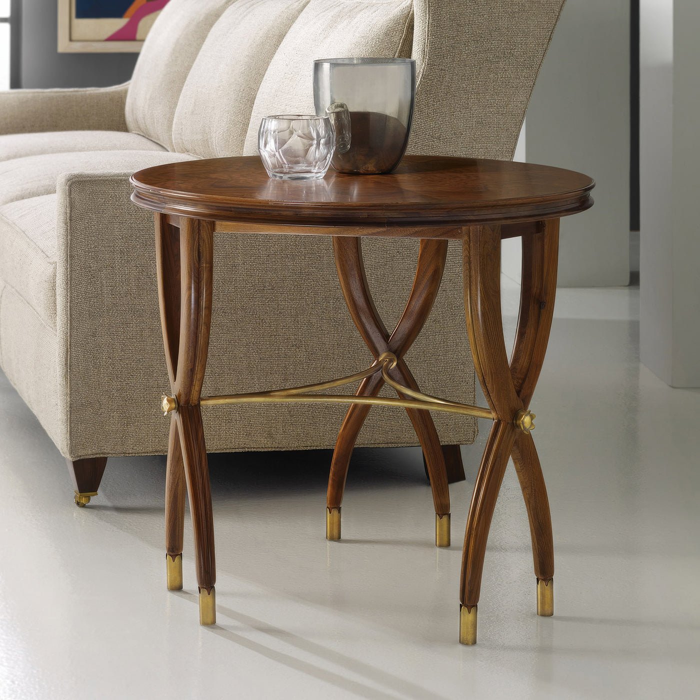 Walnut Art Deco side table by beige sofa, decorative items.