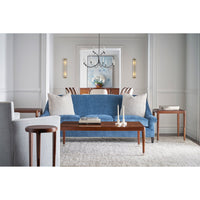 Blue sofa with walnut Art Deco side table in room.