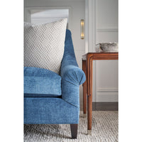 Side table next to blue sofa with pillow.