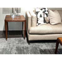 Close-up of walnut Art Deco side table by sofa.