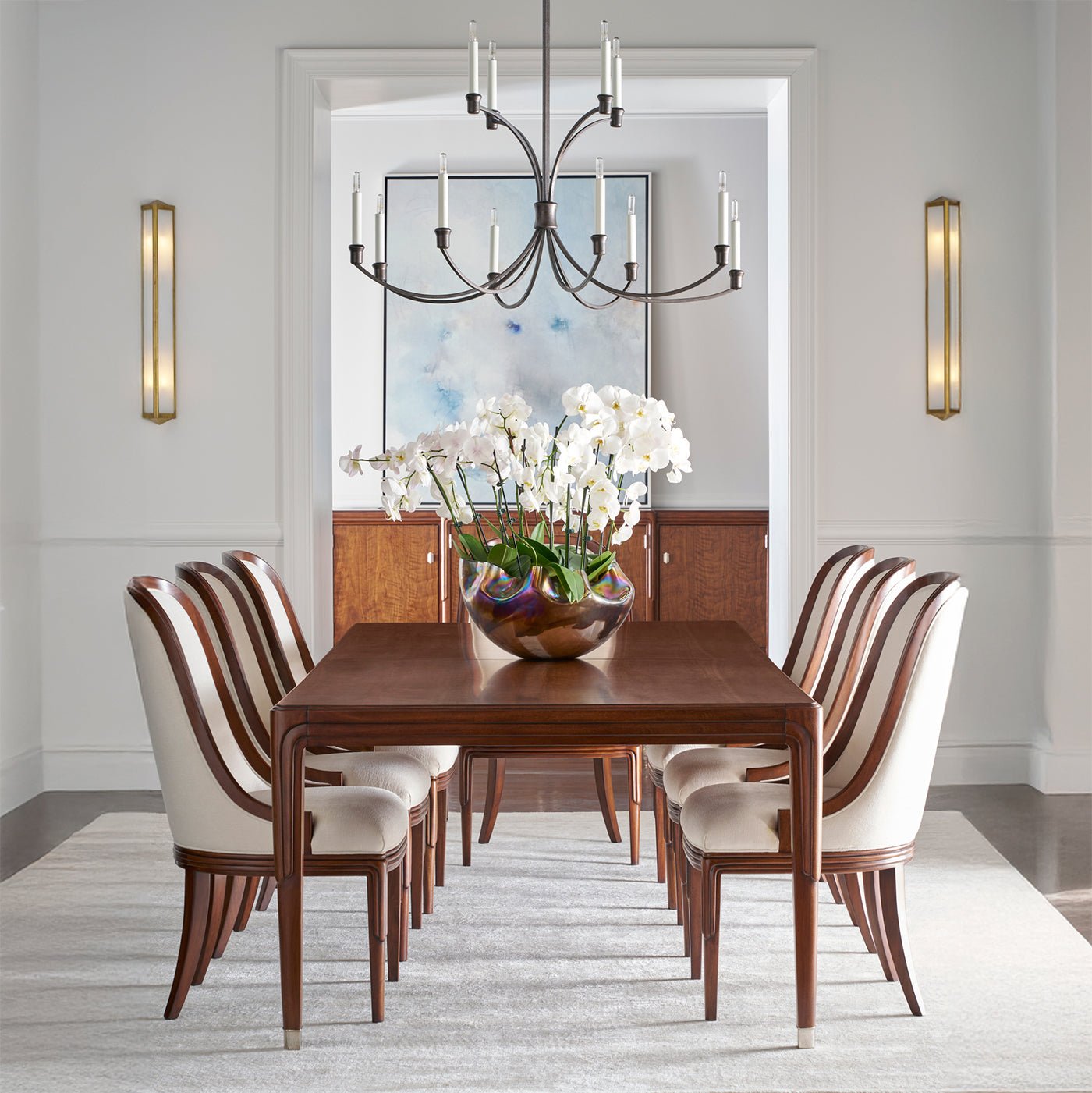 Elegant dining room setup with art deco chairs, chandelier.