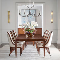 Elegant dining room setup with art deco chairs, chandelier.
