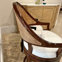 Close-up of walnut swivel bar stool, wicker backrest detail.