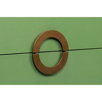 Close-up of circular handle on green nightstand.