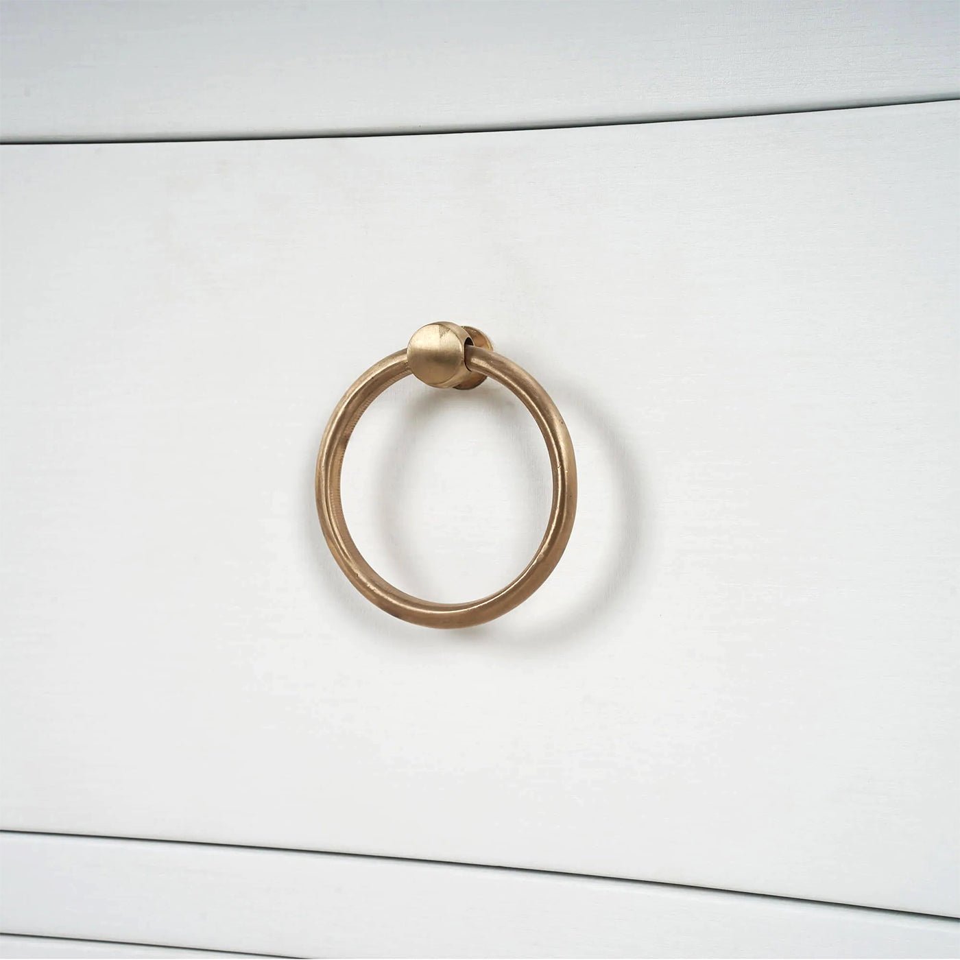 Close-up of nightstand gold ring handle detail.