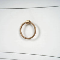 Close-up of nightstand gold ring handle detail.