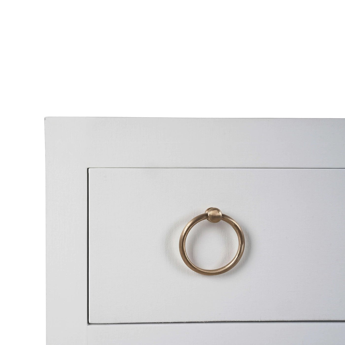 Close-up of drawer handle on white modern chest.