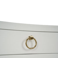 Close-up of gold handle on white linen nightstand.