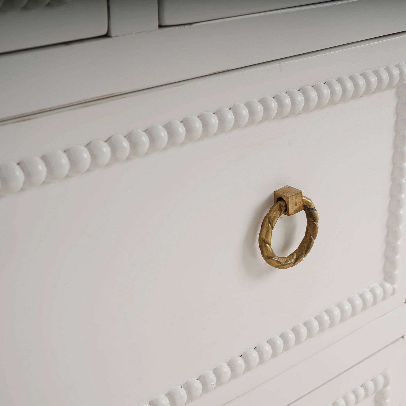 Close-up of dresser drawer with gold ring handle.