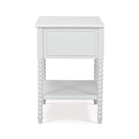 White nightstand side view, beaded legs, smooth panel.