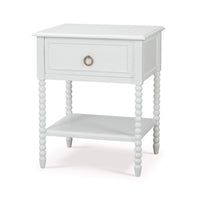 White nightstand angled view, beaded legs, drawer closed.