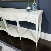 White console table with vases, dark wall background.