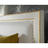 Close-up of bed headboard detailing with gold trim.