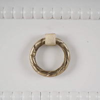 Close-up of ornate ring handle on white chest.