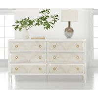 White dresser styled with plant and lamp.