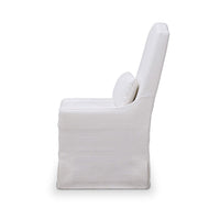 White slipcovered dining chair, side profile view.