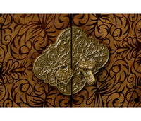 Close-up of cabinet latch, ornate floral metal design.