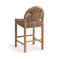 Three-quarter rear view of the brown woven abaca counter stool showing the arched back and teak frame