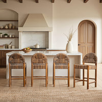 Four brown woven abaca counter stools arranged at a white kitchen island