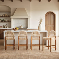 Four natural woven abaca counter stools arranged at a white kitchen island