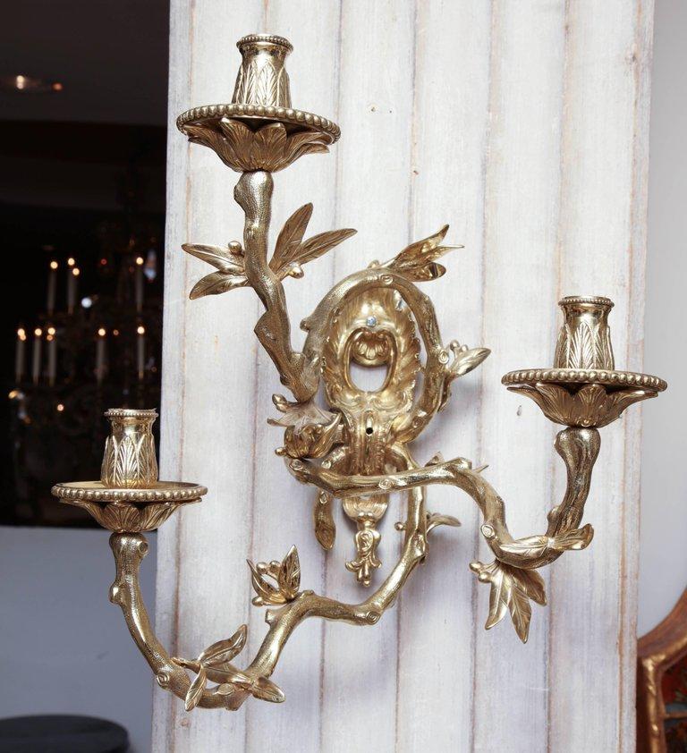 Close-up of bronze wall sconce against white panel.