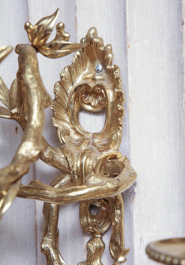 Close-up of sconce's decorative mounting detail.