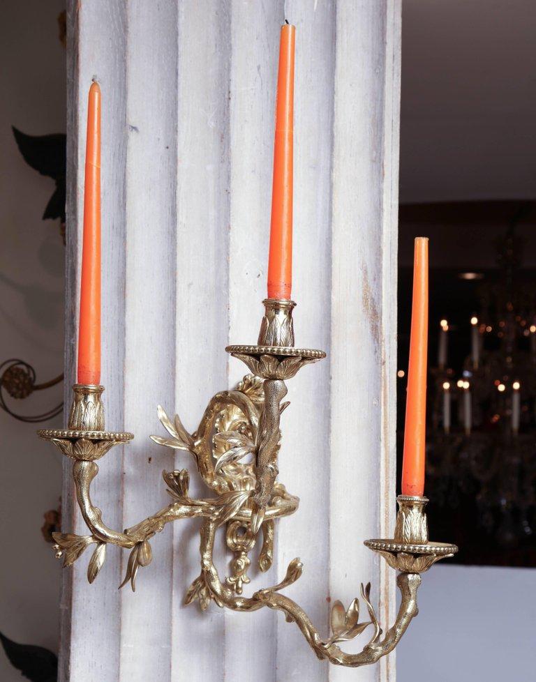 Wall-mounted bronze sconce showcasing ornate design.