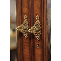Antique-style brass handle detail on walnut bookcase.